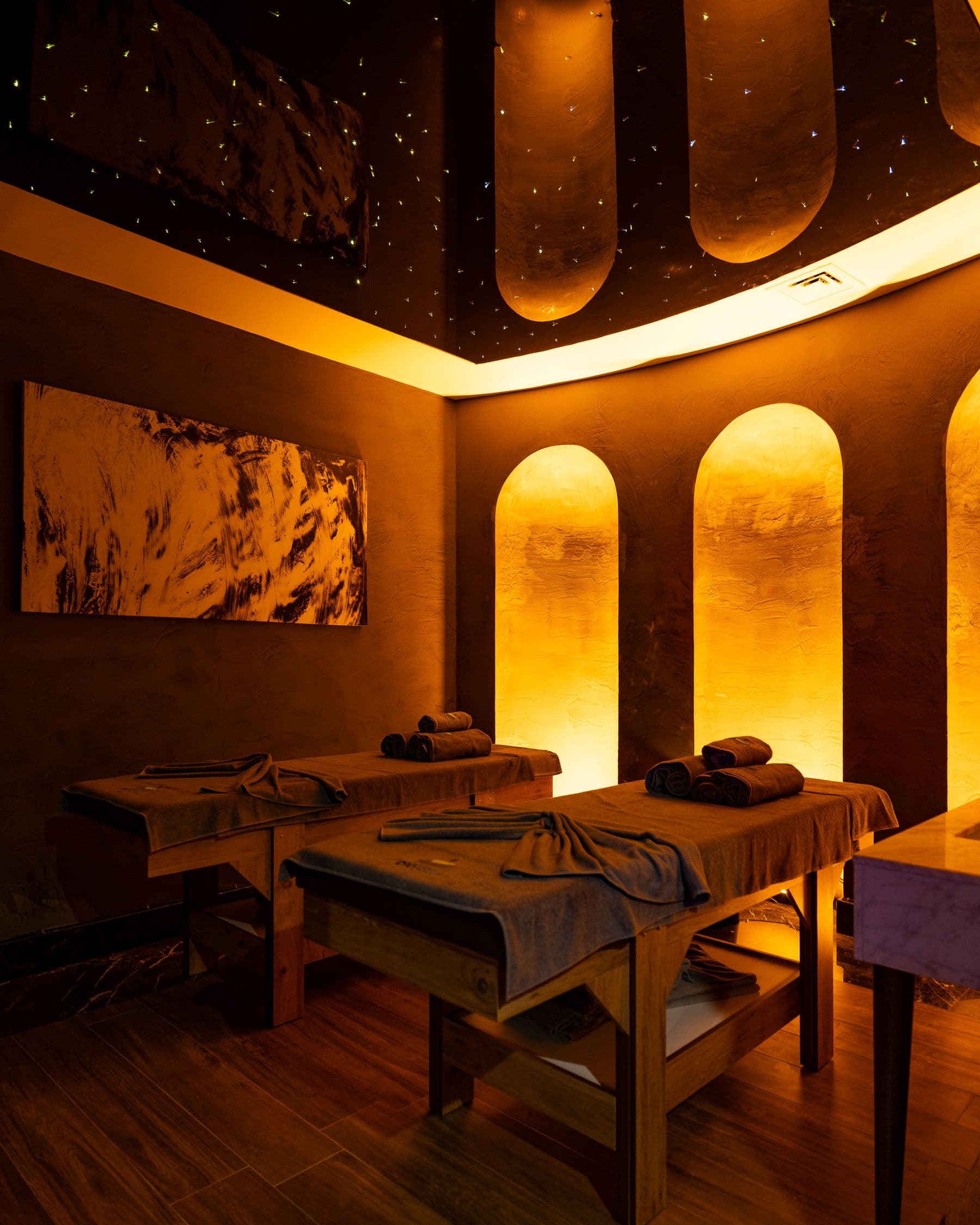 Sala de tratamientos de la clínica con arcos iluminados y luz cálida dorada
