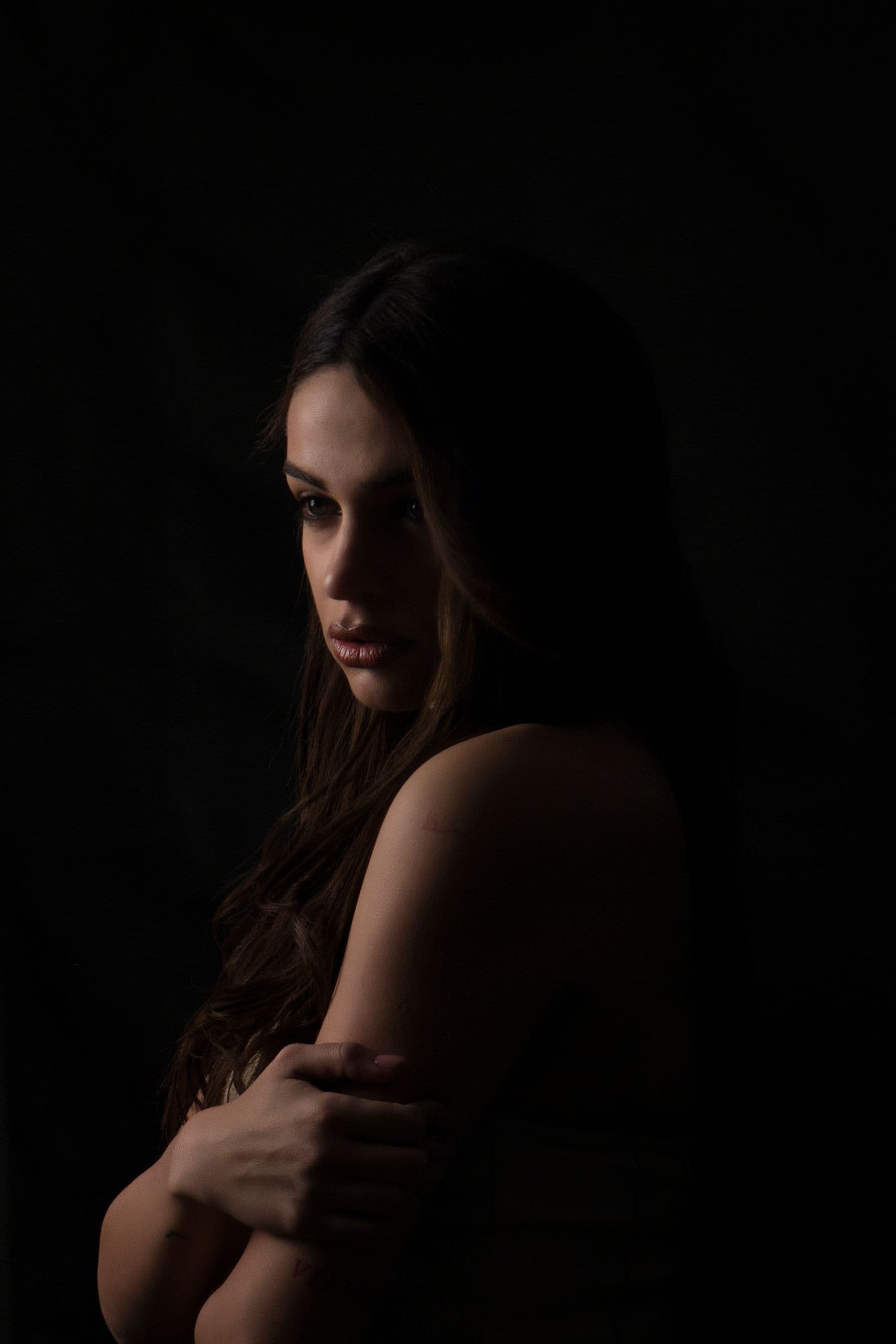 Mujer con rostro sereno y piel luminosa sobre fondo oscuro, imagen de medicina estética avanzada