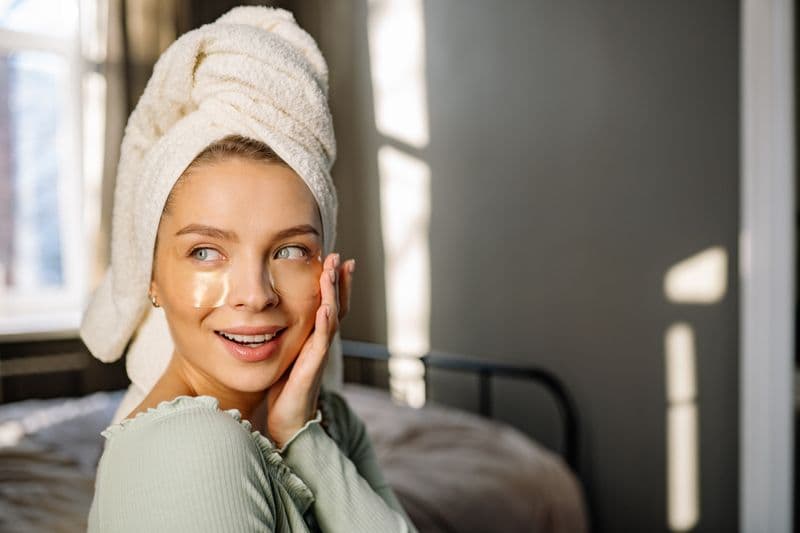 Mujer sonriente con toalla tras un tratamiento facial de rejuvenecimiento